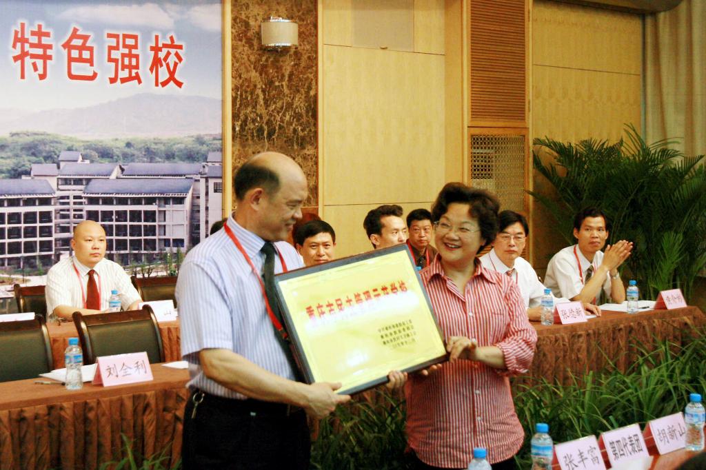 市总工会副主席王秀英为我校颁发“重庆市民主管理示范学校”奖牌