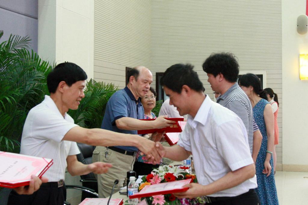 学校领导为受到表彰的王毅、郭敏娜等54名优秀共产党员个人代表颁发了证书