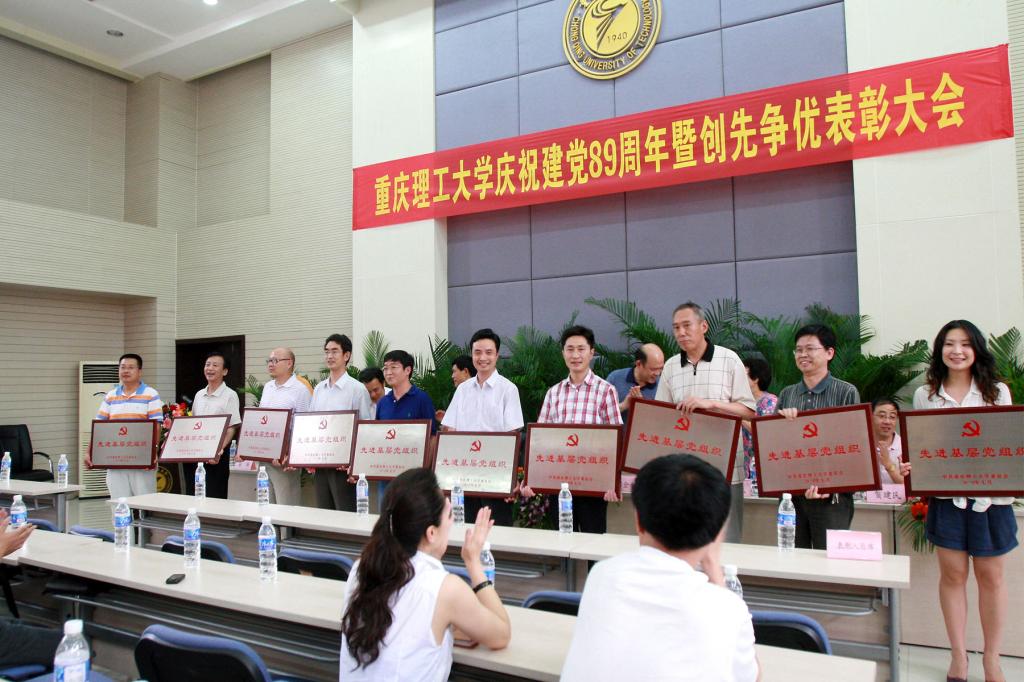 学校领导为受到表彰的机关第一党总支等11个先进基层党组织颁发了奖牌