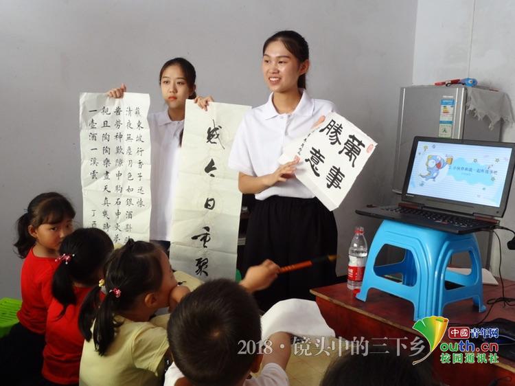 志愿者为小朋友展示优秀书法作品 中国青年网通讯员 况镇成 摄